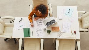 Woman working on reports on a desk seen from above